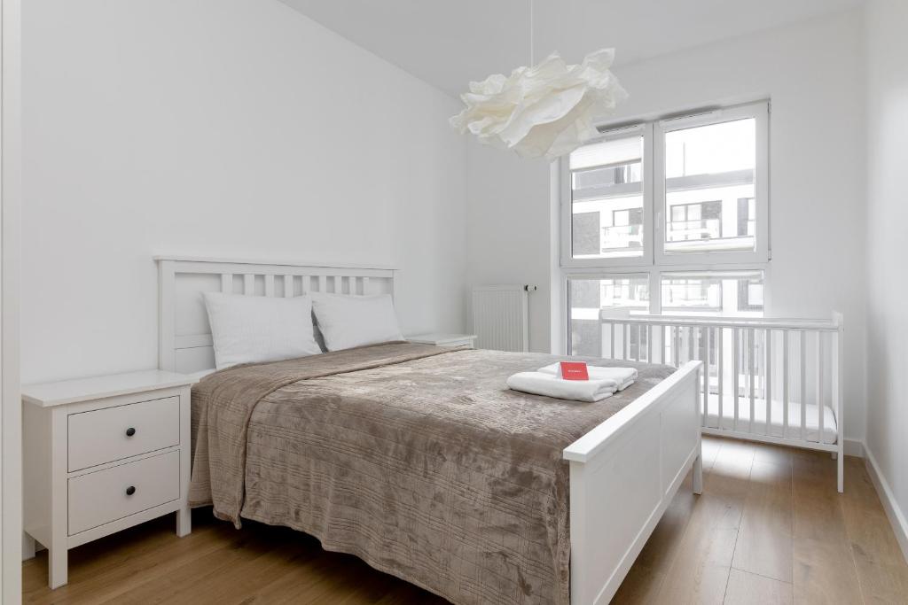 biała sypialnia z łóżkiem i oknem w obiekcie Rozłogi Sunny Apartment w Warszawie