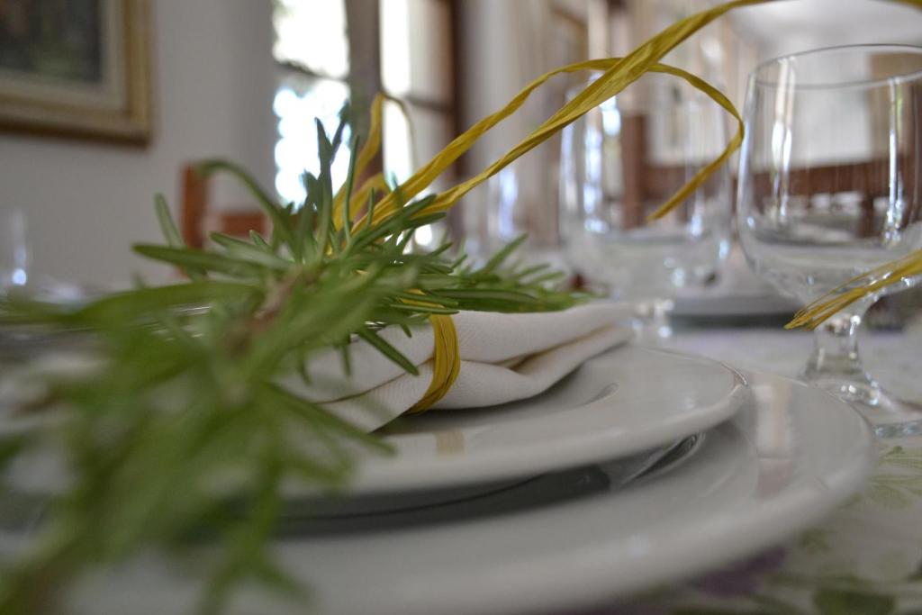 un tavolo con un piatto bianco con una pianta di La Locanda di Valbella ad Asti