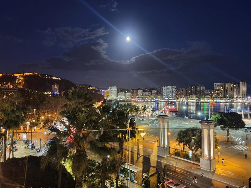 - une vue sur une ville la nuit avec la lune dans l'établissement Centro Malaga, à Malaga