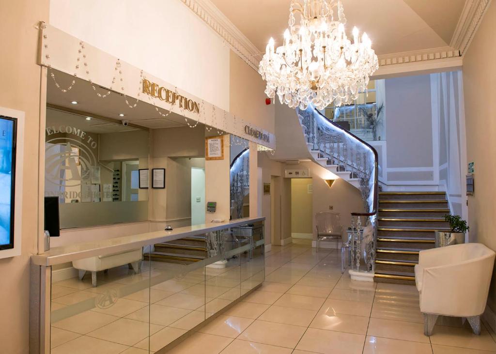 a large lobby with a staircase and a chandelier at Avonbridge Hotel in Hamilton