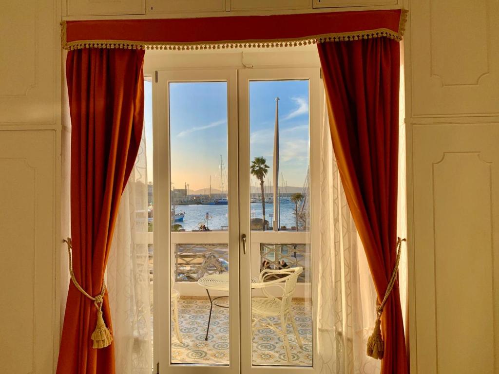 a room with a window with a view of the water at Dolce Vita Suite Alghero in Alghero