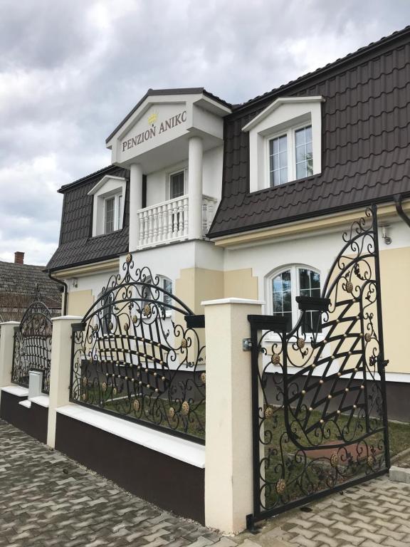 a white house with a black gate at PENZION ANIKO DIAKOVCE-ŠAĽA in Diakovce