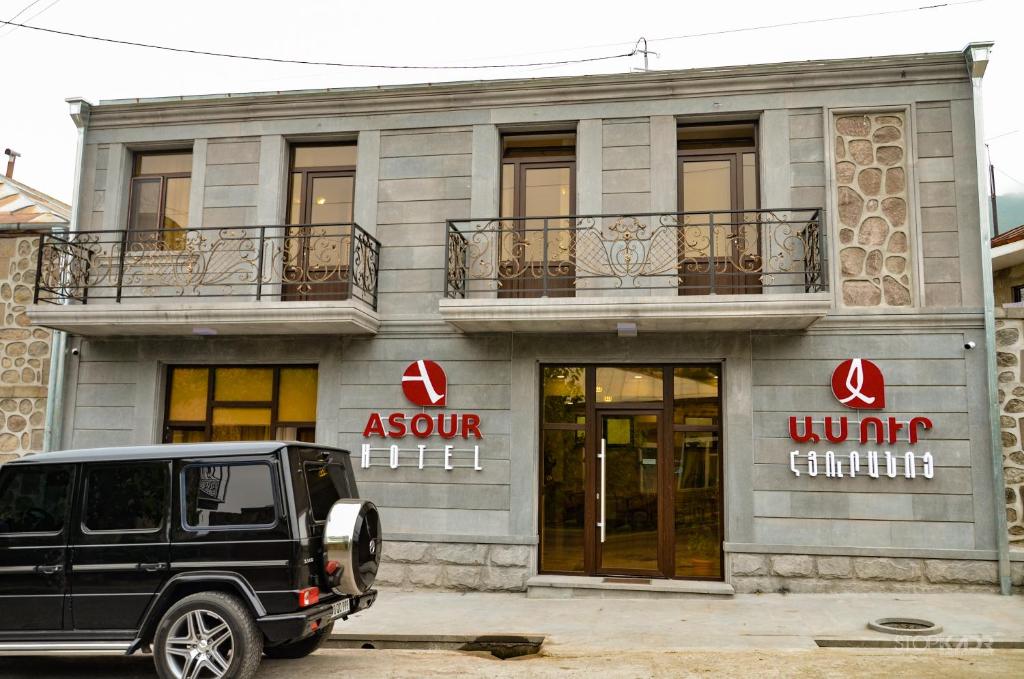 a black jeep parked in front of a building at ASOUR HOTEL in Goris