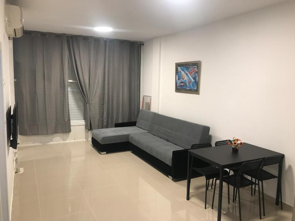 a living room with a couch and a table at Isramax Apartment near the sea. in Bat Yam