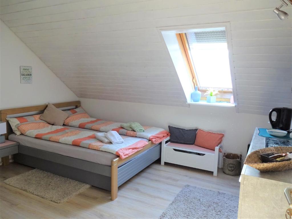 um pequeno quarto com uma cama e uma janela em Gästezimmer in Bad Urach em Bad Urach