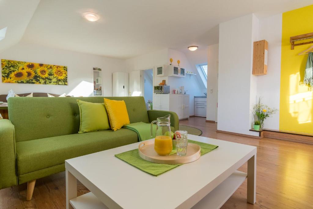 a living room with a green couch and a table at Ein Bett im Norden in Fehmarn