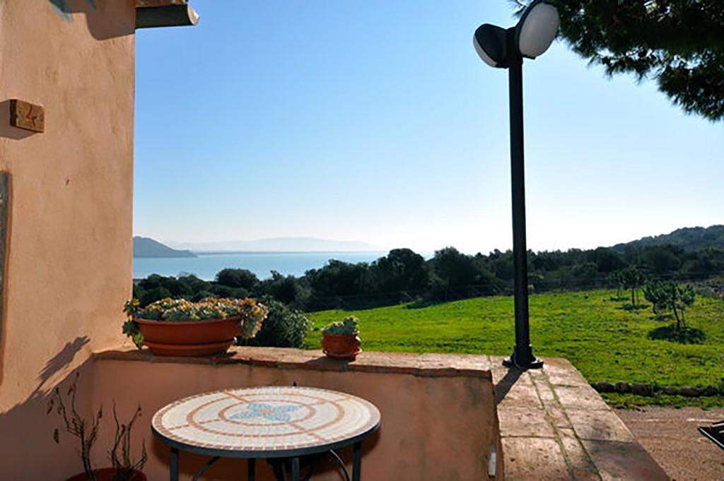 a table sitting on a wall with a view of a field at Podere Caprarecce Trilocale 6 in Talamone