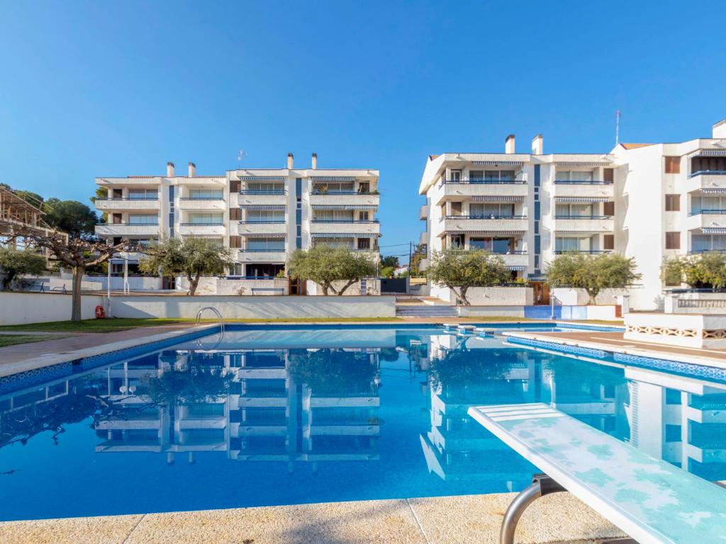 una piscina con dos edificios de apartamentos en el fondo en Apartment Ursula by Interhome, en Torredembarra