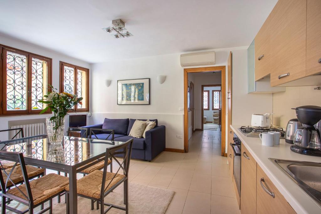 Il comprend une cuisine et un salon avec une table et des chaises. dans l'établissement Appartamento Sant'Anzolo, à Venise