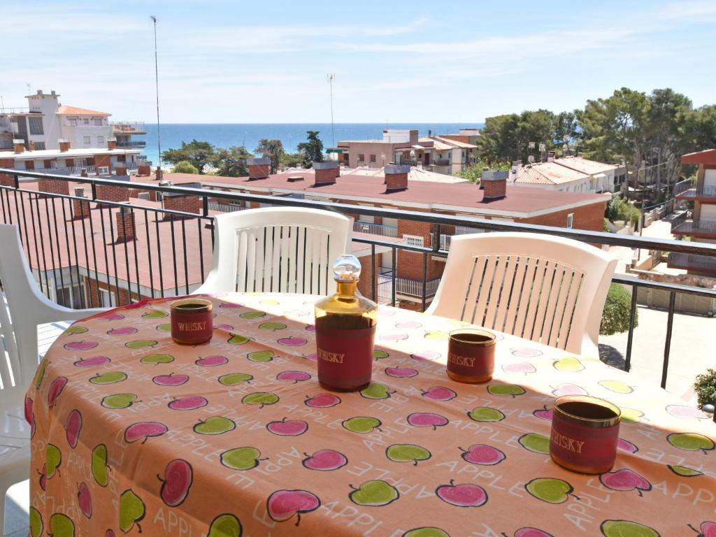 uma garrafa de vinho sentada numa mesa na varanda em Apartment Helen by Interhome em Torredembarra