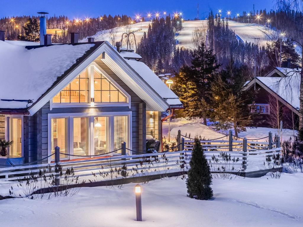 a house in the snow with a candle in front at Holiday Home Akavilla 2 by Interhome in Jämsä