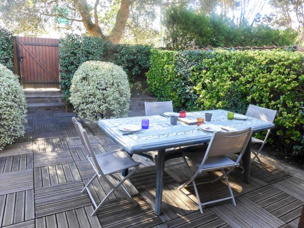 une table et des chaises bleues sur une terrasse dans l'établissement Holiday Home lotissement Les Rives de Capbreton by Interhome, à Capbreton