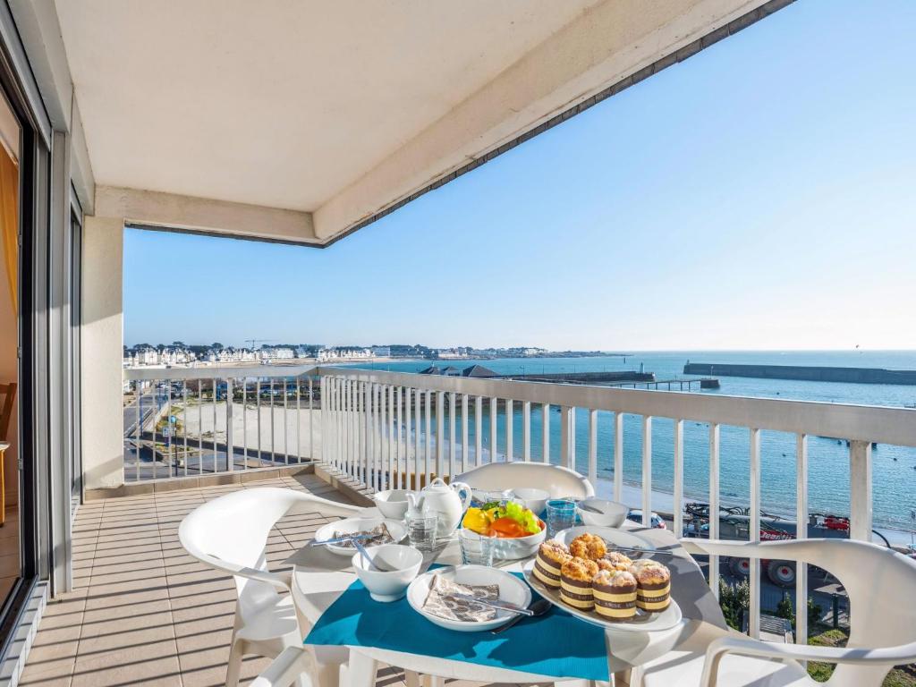 une table avec de la nourriture sur un balcon avec vue sur l'océan dans l'établissement Apartment Port Maria-2 by Interhome, à Quiberon