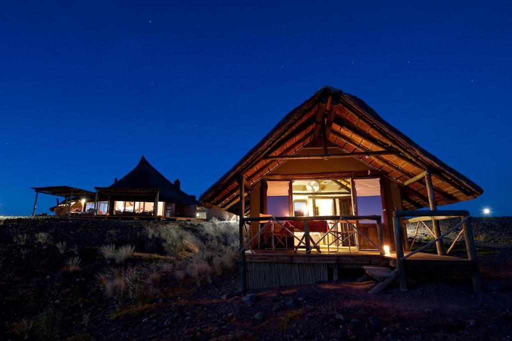 a cabin at night with the lights on at Wilderness Safaris Kulala Desert Lodge in Sesriem