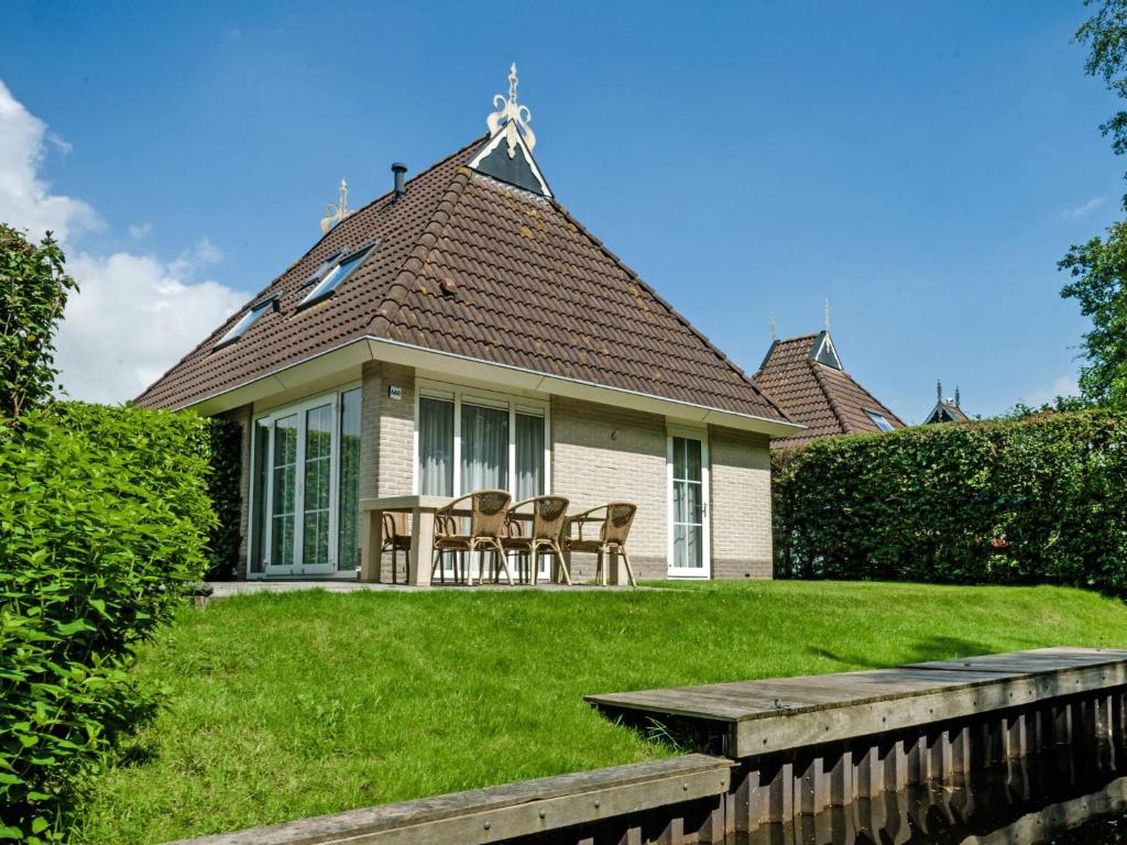 ein Haus mit Stühlen und einem Tisch im Hof in der Unterkunft Holiday Home Bungalowpark It Wiid by Interhome in Eernewoude