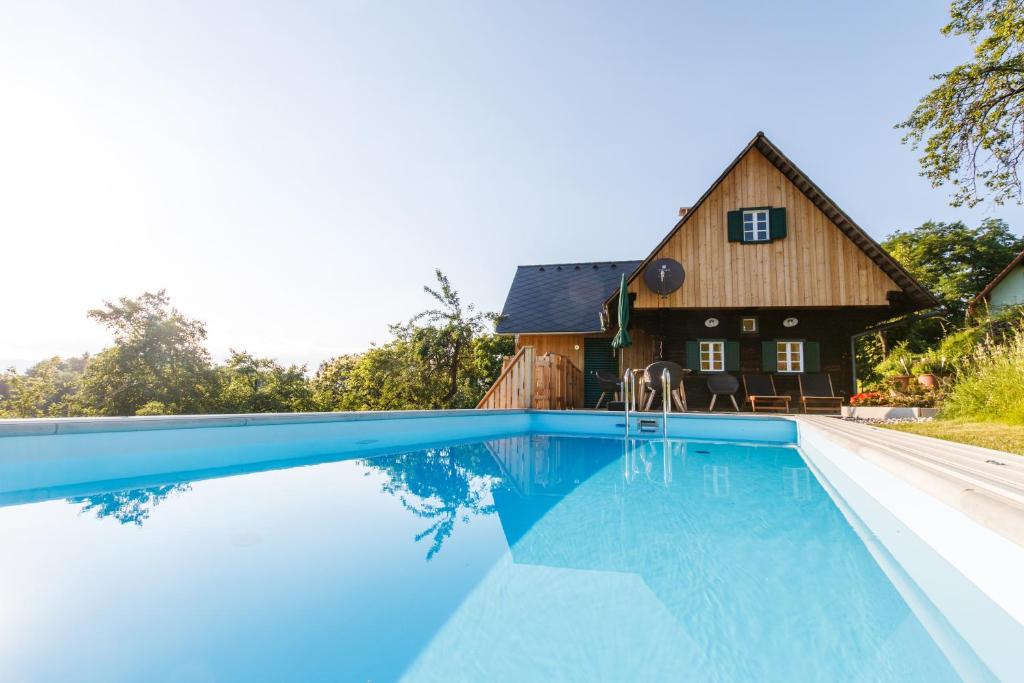 una casa con piscina frente a una casa en Ferienhaus Riegelnegg, en Oberhaag