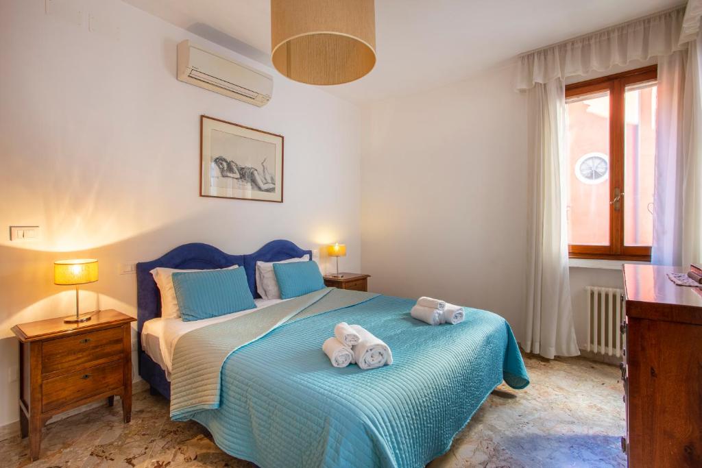 een slaapkamer met een blauw bed en handdoeken bij Ca degli Angeli in Venetië