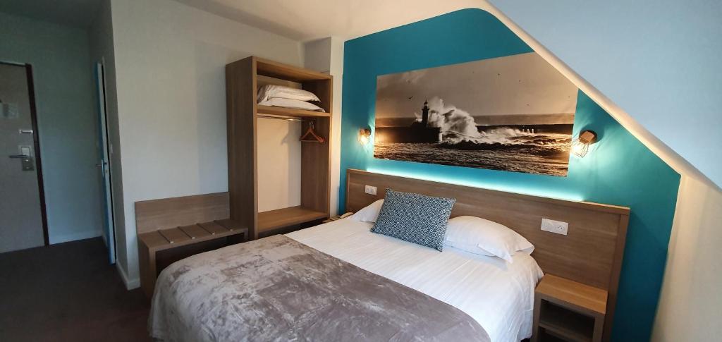 a bedroom with a bed with a painting on the wall at The Originals City, Hôtel Les Océanes, Lorient in Lorient