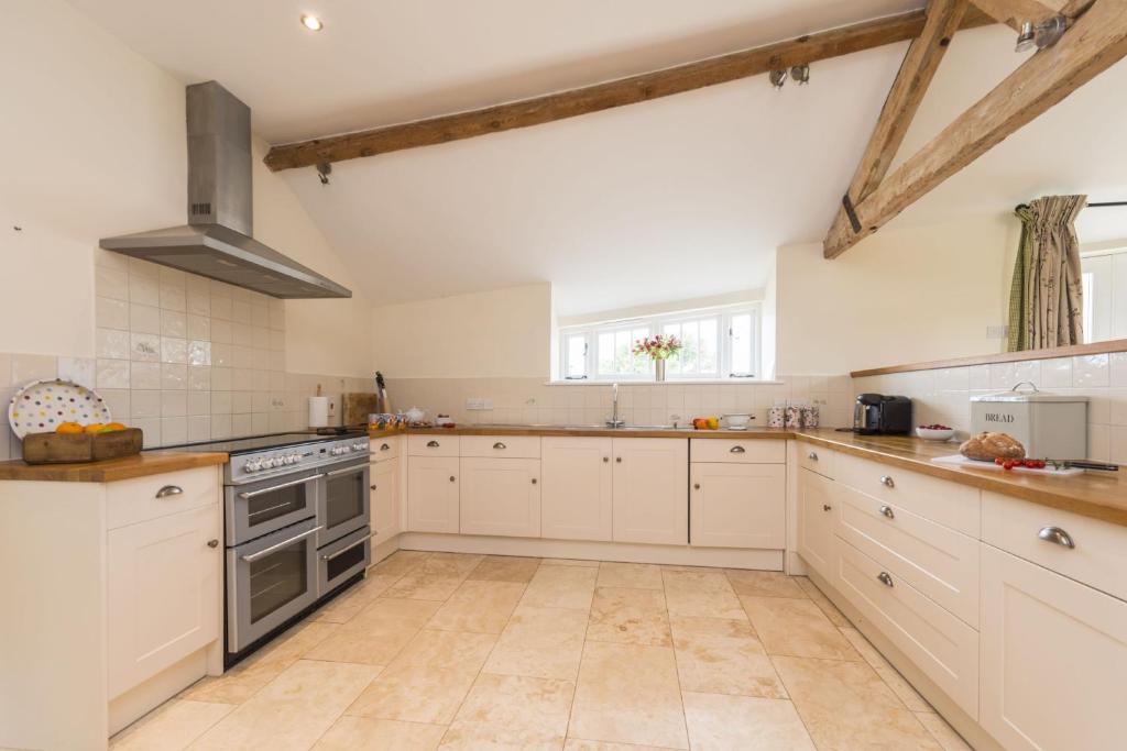 a kitchen with white cabinets and a stove top oven at Clayhanger Lodge in Abbotsbury