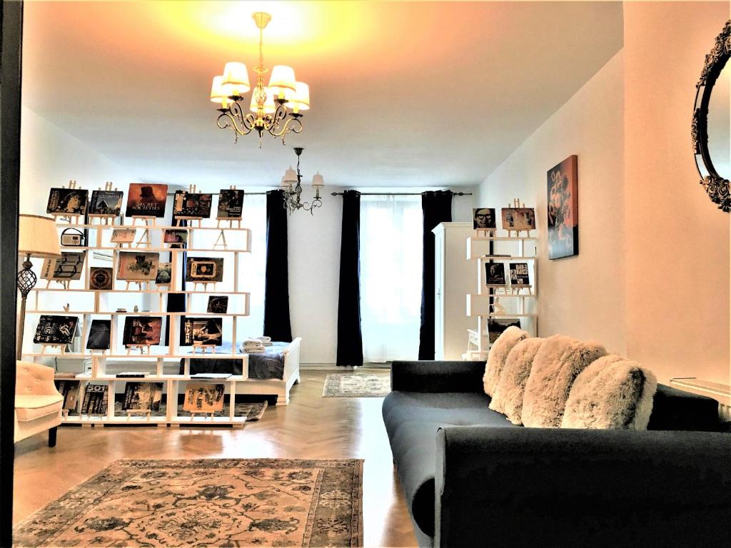 a living room with a couch and a chandelier at White Wolf Apartment in Braşov