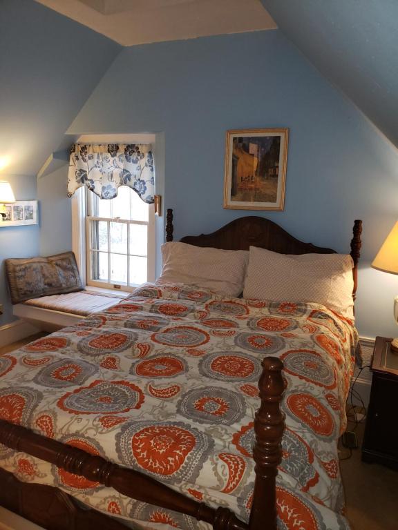 um quarto com uma cama com uma colcha em English Cottage em Greensboro