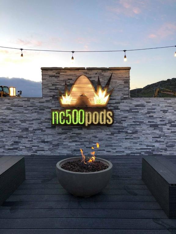a sign on a brick wall with a fire pit at North Coast 500 Pods in Achmelvich