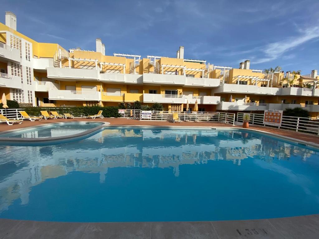 a large swimming pool in front of a hotel at Apartamento T2 com piscina em Conceição e Cabanas de Tavira in Tavira