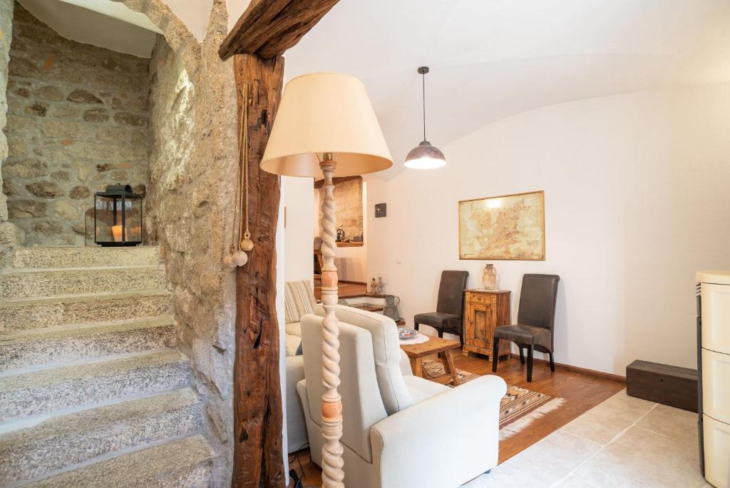 sala de estar con escaleras, mesa y sillas en Casa Santa Croce en Alà dei Sardi