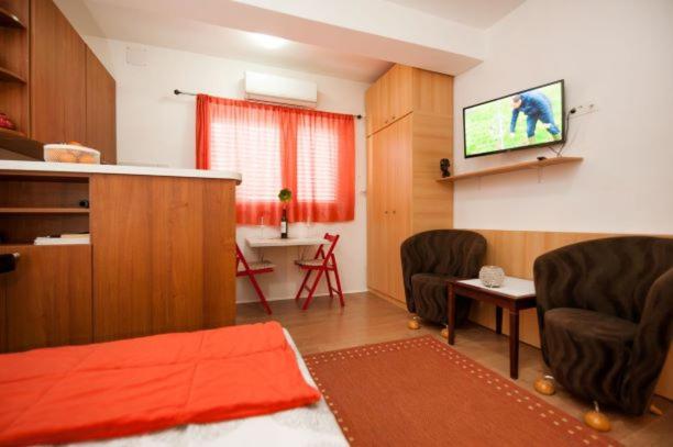 een woonkamer met 2 stoelen en een flatscreen-tv bij Centar 1 Private Room with Ensuite and Kitchenette in Split