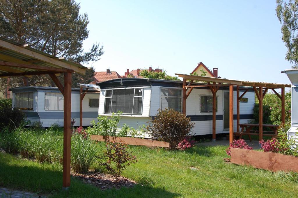 ein Haus mit einer Pergola im Hof in der Unterkunft Ośrodek Wypoczynkowy ADA in Mielno
