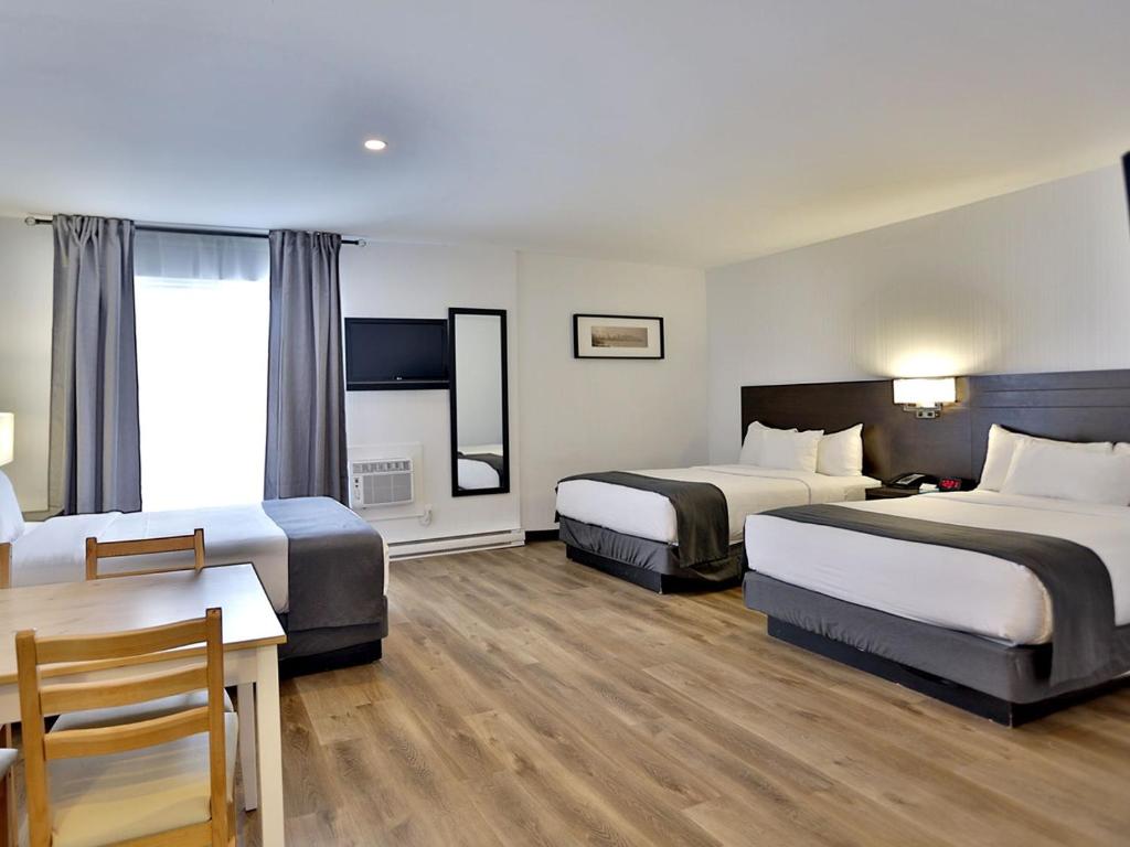 een hotelkamer met 2 bedden en een tafel bij Hotel Newstar Montréal in Montreal