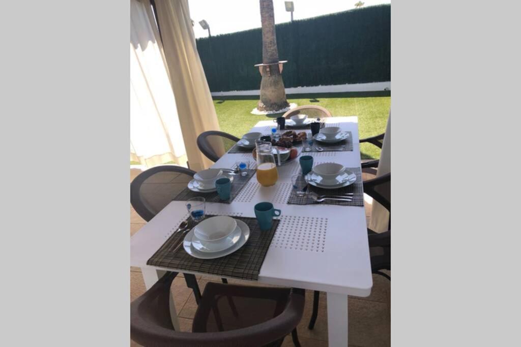 a white table with plates and drinks on it at Sonora Aircon Bungalow 121 in Maspalomas