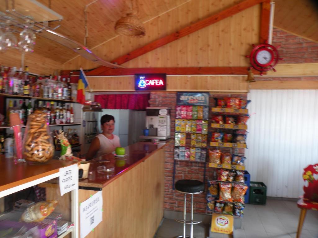 una tienda con una mujer detrás del mostrador de una tienda en Camping Paradisul Soferilor en Onești