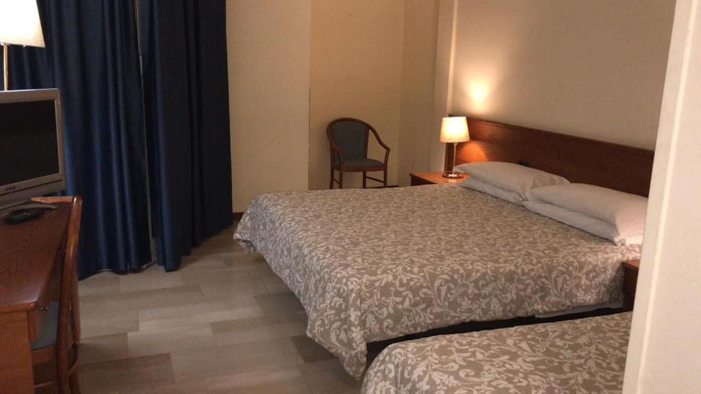 Habitación de hotel con 2 camas y TV en Hotel Select, en Sant'Ilario d'Enza