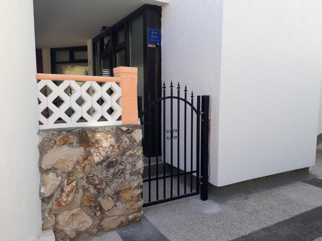 a black gate on the side of a building at Apartman Roko in Novalja