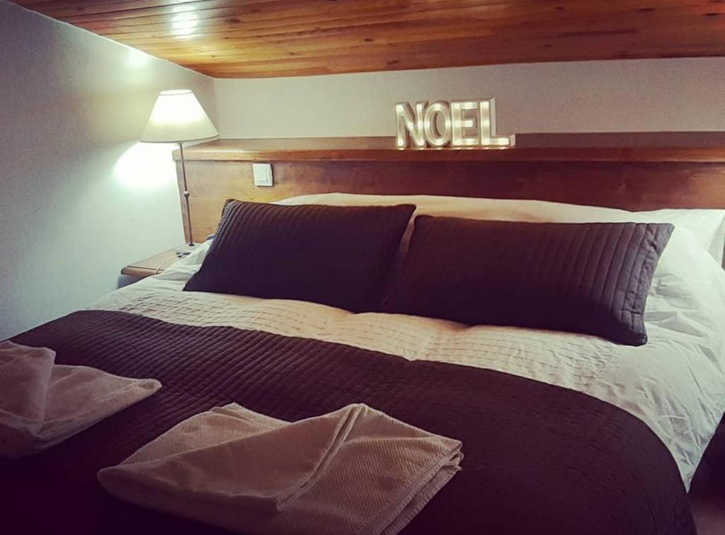 a bed in a bedroom with a sign on the wall at Luxury Apartment MONTCHAVIN in Montchavin