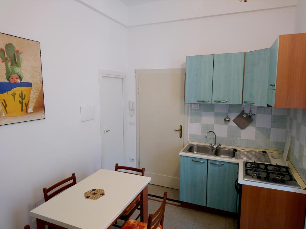 - une cuisine avec des placards bleus, une table et un évier dans l'établissement Grottammare mon amour Ponente, à Grottammare