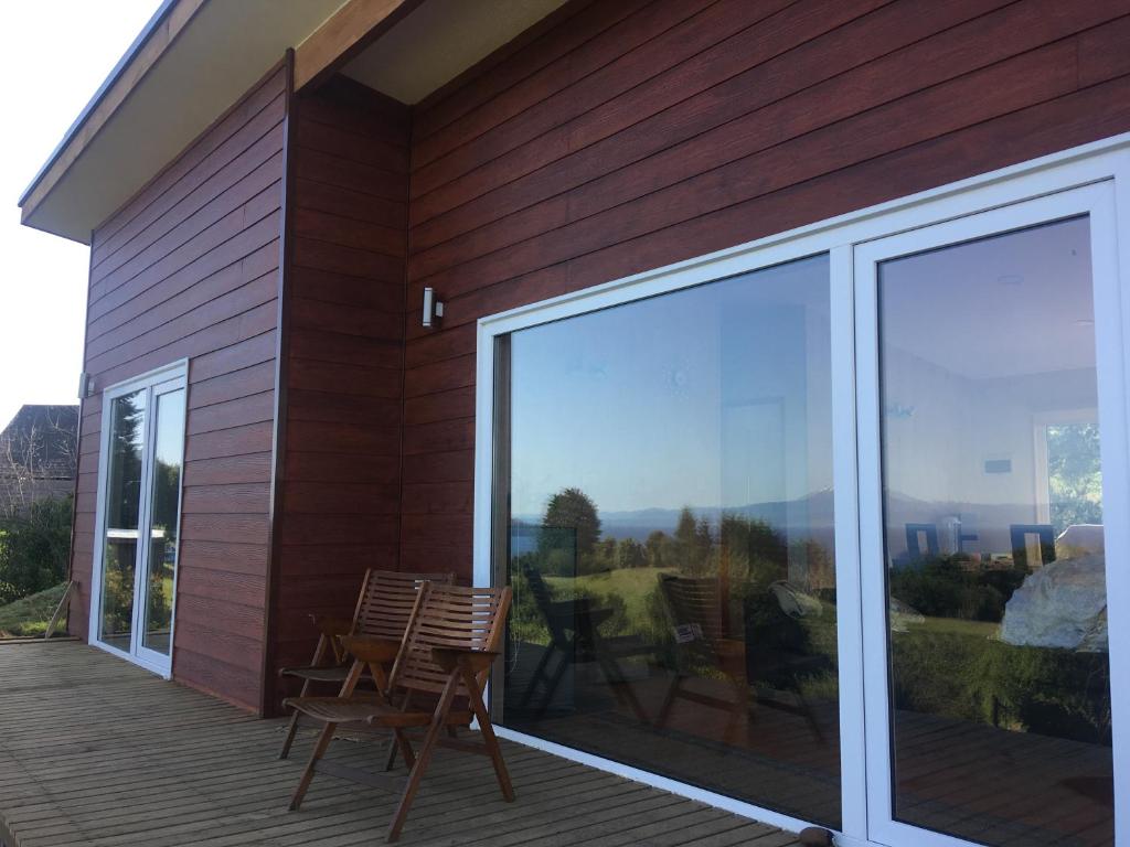 eine Terrasse mit Stühlen und einer Glasschiebetür in der Unterkunft Casa Exclusiva en Puerto Octay - Espectacular Vista in Puerto Octay