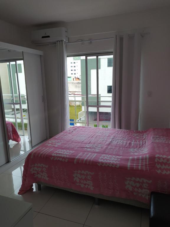 Un dormitorio con una cama y una ventana grande en Apartamento no centro - 2, en Balneário Camboriú