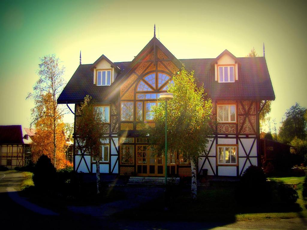 una gran casa marrón y blanca con el sol brillando en ella en Vila Kalinčiak AESCULAP, en Dolný Smokovec