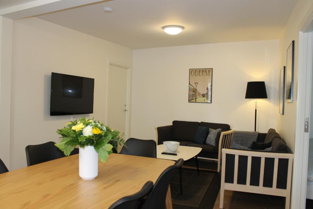 een woonkamer met een tafel en een bank bij Odense Apartments in Odense