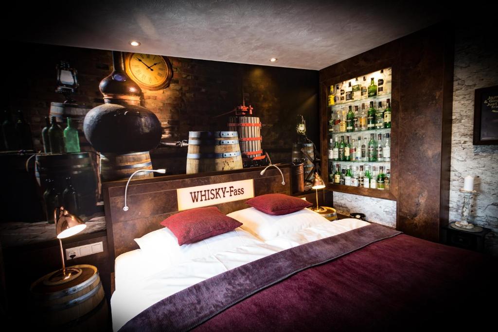 - une chambre avec un lit et une étagère avec des bouteilles dans l'établissement Hotel Röhrsdorfer Hof, à Chemnitz