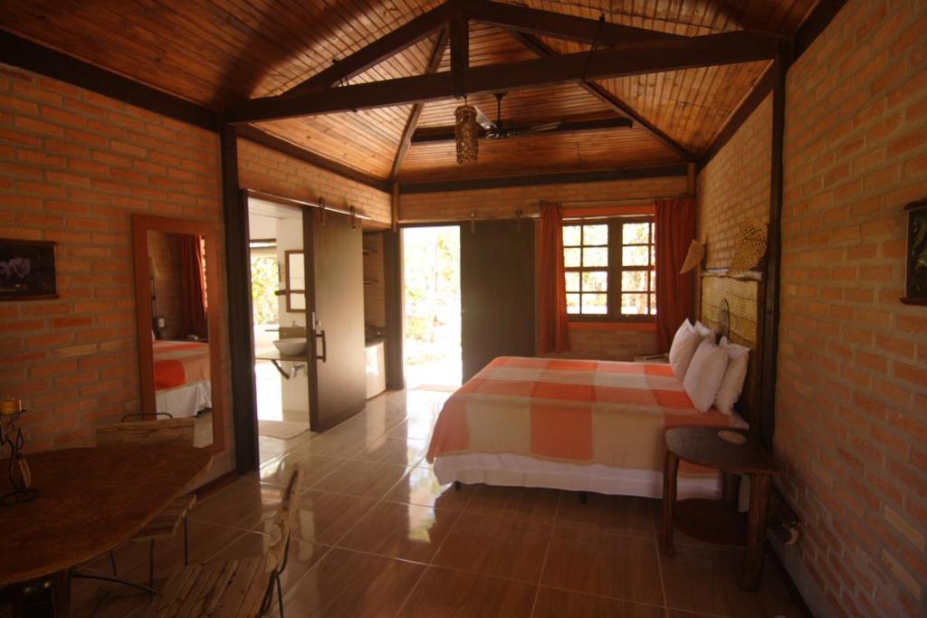 a bedroom with a bed in a brick wall at Pousada Vale das Araras in Cavalcante