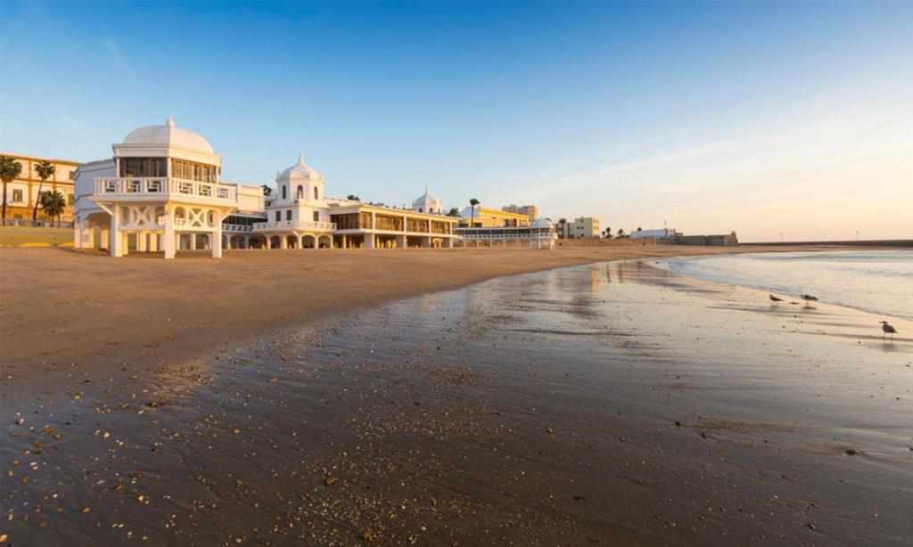 a view of a beach with houses on it at Playa La Caleta La Viña Cadiz PLAZA GARAJE GRATIS in Cádiz