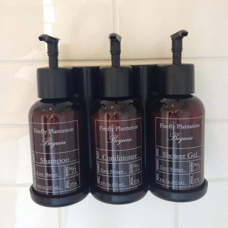 a group of four bottles of soap on a shelf at Firefly Estate Bequia in Crescent Beach
