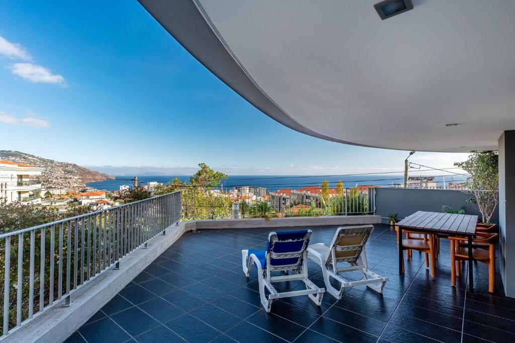 フンシャルにあるVirtudes Ocean view with pool by HR Madeiraの海の景色を望むバルコニー(テーブル、椅子付)