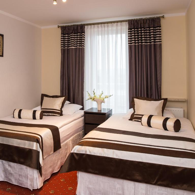 two beds in a room with a window at Motel LESTA in Lachówka Duża