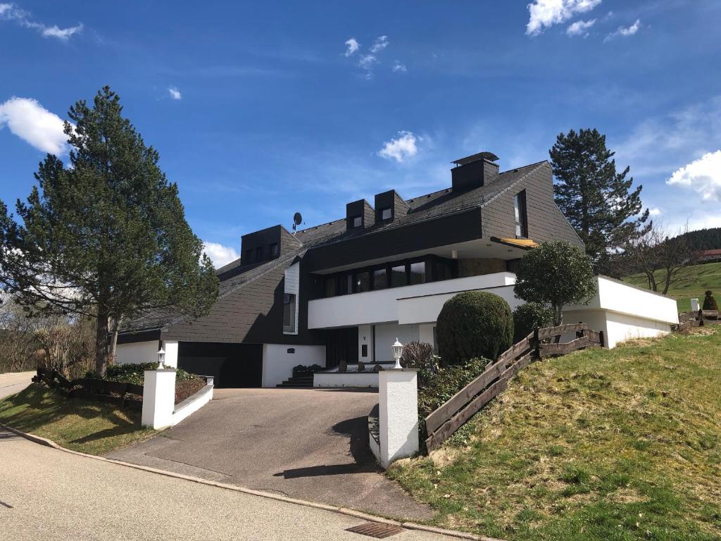 une maison sur une colline avec une allée dans l'établissement Luxus-Landhaus im Schwarzwald/Baiersbronn mit Pool, à Baiersbronn
