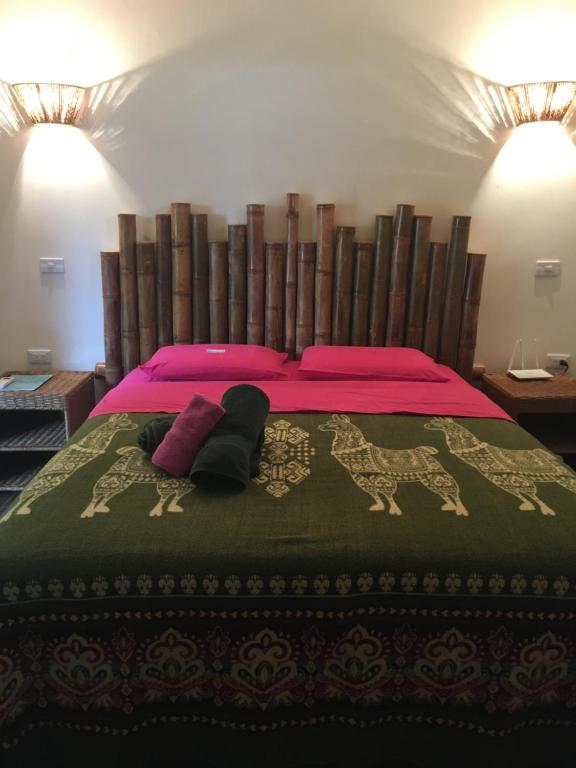 1 dormitorio con 1 cama grande con almohadas rosas en CASITA MADAME, en Puerto López