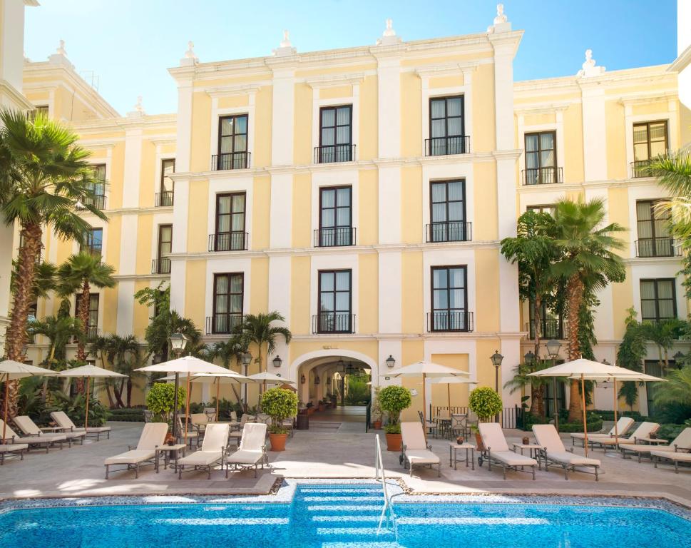 un gran edificio amarillo con sillas y piscina en Hotel Solar de las Animas, en Tequila